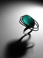 Dramatic studio shot of a gemstone ring with a teal center and black metal framework