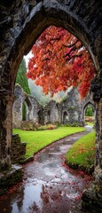 Stone arch framing autumn colors of a ruin, with wet path reflecting the scene