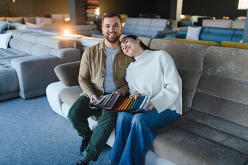 Couple choosing fabric samples for buying sofa