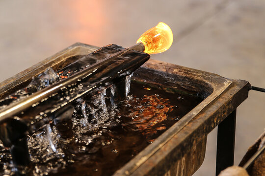 Glowing molten glass on the end of a blowpipe 