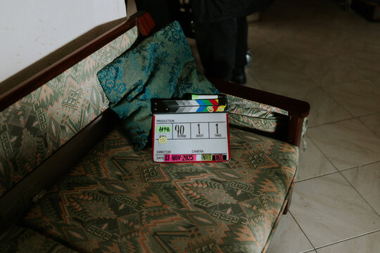 Movie clapperboard on vintage sofa with patterned fabric