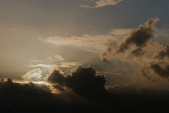 Dramatic sky with sunbeams through clouds at sunset