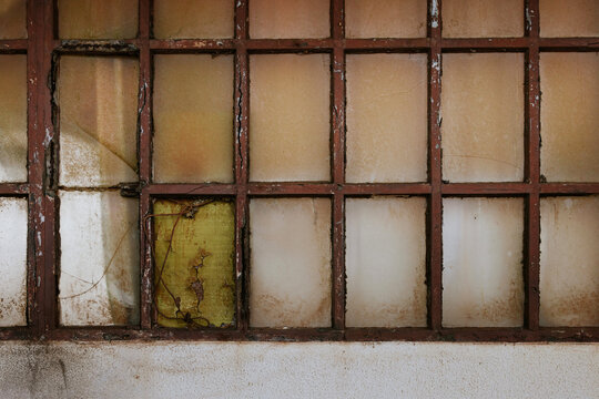 Weathered window with rusty metal grid