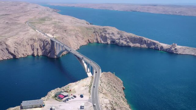 Curved bridge over sea near island Pag aerial view