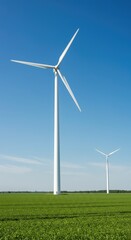 Fototapeta premium A large white wind turbine stands tall in a lush green field under a blue sky, generating clean renewable electricity ,green power ,climate ,conservation