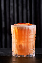Refreshing orange citrus cocktail in a crystal rocks glass on a dark background