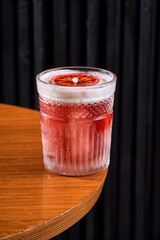 Refreshing orange citrus cocktail in a crystal rocks glass on a dark background