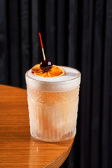 Refreshing orange citrus cocktail in a crystal rocks glass on a dark background