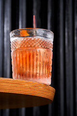 Refreshing orange citrus cocktail in a crystal rocks glass on a dark background