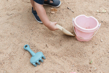 Child playing with sand toys in sandbox