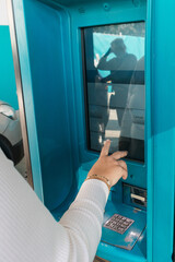 Woman hand touching screen at gas station payment terminal
