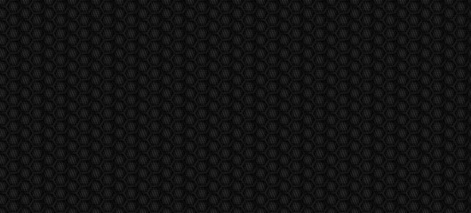 Black carbon fiber texture with hexagonal honeycomb pattern. Abstract dark metallic background for automotive luxury design, racing sport backdrop, and modern tech wallpaper. Seamless fiber surface.