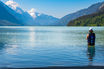 Woman fishing in a lake at the foot of the mountains in Alaska