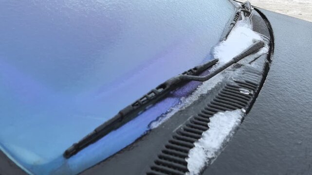 View the captivating process of a car windshield forming ice and frost as freezing rain falls during a cold winter day. Witness natures beauty in icy detail and how winter affects vehicles.