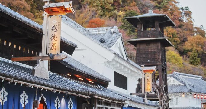 Autumn trees over ancient Japanese buildings and tower
