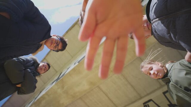 Curious family looking down into camera opening a box