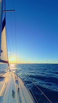 Valencia sailboat at sunset cruising on Mediterranean sea with golden light