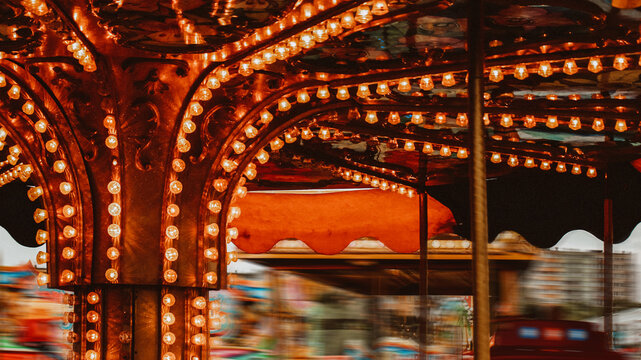 Spinning carousel with warm rustic lights bulb at fairground in Gniezno Poland