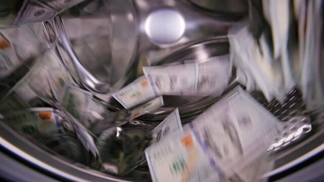 Hundred United States Dollar banknotes bouncing around inside washing machine for money laundering and fraud concept.