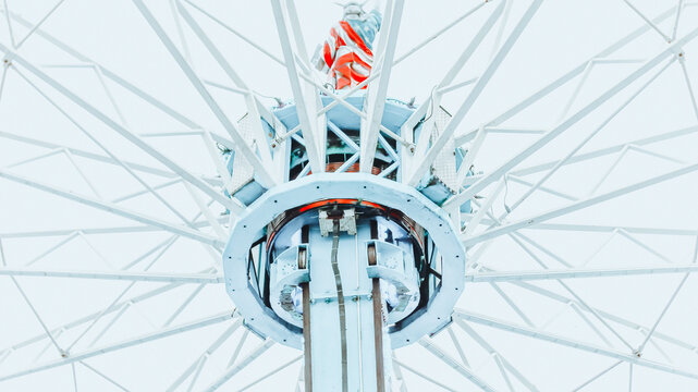 Blue amusement park carousel tower viewed from below against sky
