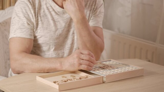 senior man focused on solving sudoku puzzle on wooden board, Brain exercise, cognitive health, and mental agility in mature age, mental stimulation, brain health