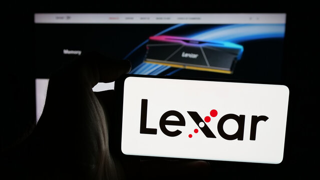 Stuttgart, Germany - 01-22-2026: Person holding mobile phone with logo of US memory storage company Lexar International on screen in front of web page. Focus on phone display.