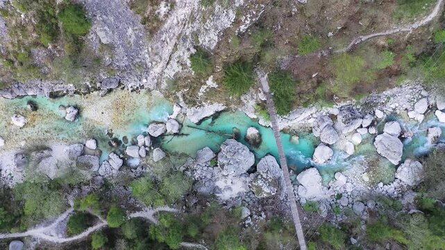 Turquoise river and footbridge in canyon aerial view