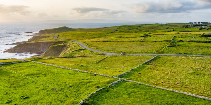 Aerial view of Mullaghmore Head with huge waves rolling ashore. Picturesque scenery with green pastures and meadows. Signature point of the Wild Atlantic Way, County Sligo, Ireland