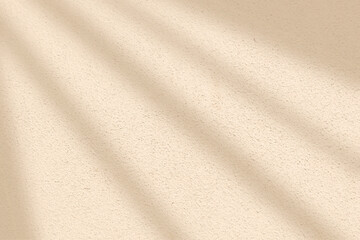 Light and shadow from window on beige wall texture