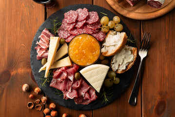 Piatto con prosciutto crudo, salame, guanciale, crostini con crema di formaggio, parmigiano, pecorino, frutta secca e frutta fresca  - Antipasti Italiani 