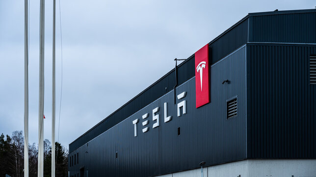 Stockholm, Sweden - March 09 2024: tesla manufacturing facility exterior with logo and flagpoles.