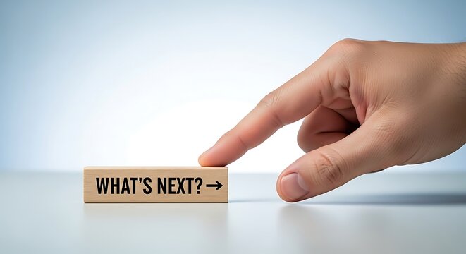 Finger pointing at wooden block with whats next text and arrow