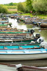 Fototapeta premium Assorted boats for rent tied to small pier on Lough Leane, the largest and northernmost of the lakes of Killarney National Park, County Kerry, Ireland