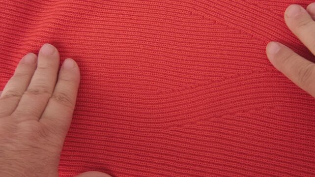 female Hand touching knitted wool cloth or warm fluffy sweater, Handcraft knitting woolen fabric surface, tactile properties, fabric testing