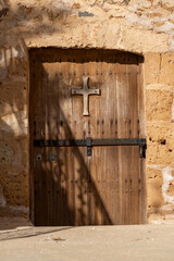 Old Wooden Church Door with Cross in Stone Wall