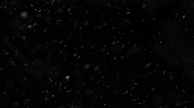 Snowfall on a black background for compositing. Floating snow particles move across the frame, ideal for screen or overlay blending modes in cinematic, holiday, and visual effects projects.