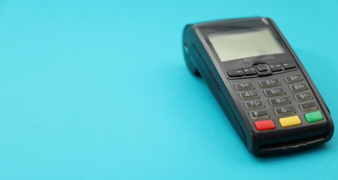 One payment terminal on light blue background, closeup. Space for text
