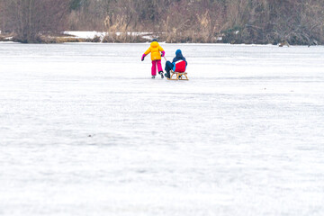 Kinder mit Rodel am Eis