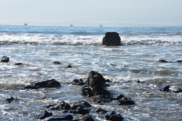 Asphalt Rocks in the Ocean with Waves Crashing