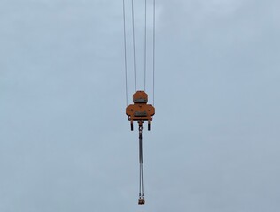 minimalist construction equipment depiction, suspended crane hook with cable in overcast outdoor © Nataliia