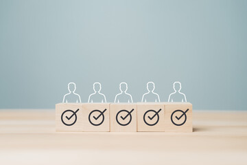 Naklejka premium Minimal business concept show wooden blocks with check mark and people icon aligned in row, representing approved selection, verified candidate, quality control, recruitment success, team evaluation.