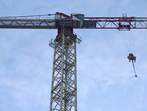 crane silhouette scene, highrise construction crane with cab and cable tension amid cloudy sky