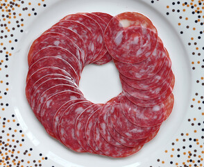 Sausage pieces laid in a circle on a white plate
