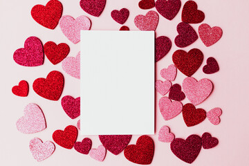 Happy Valentine's day greeting card! Empty card with space for text and stylish pink and red hearts flat lay on pink paper background. Modern love postcard mockup