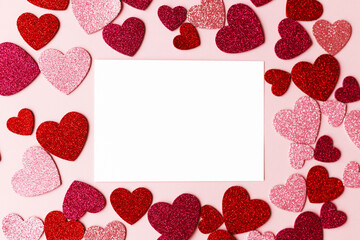 Happy Valentine's day greeting card! Empty card with space for text and stylish pink and red hearts flat lay on pink paper background. Modern love postcard mockup