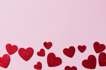Happy Valentine's day! Stylish red glitter hearts flat lay on pink paper background. Modern cute love banner. Valentine card with space for text