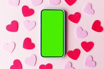 Valentine's day phone mockup. Empty phone screen flat lay with stylish pink and red glitter hearts on pink paper background. Happy Valentine's day smartphone template with space for text