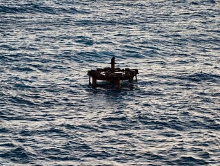 Obraz premium Weathered platform amid ocean waves, Nautical survey site with aged metal and ocean backdrop