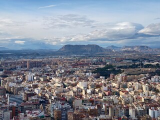 Fototapeta premium Luminous thoroughfares and wide avenues stretch into scenic mountain backdrop with hopeful skyline