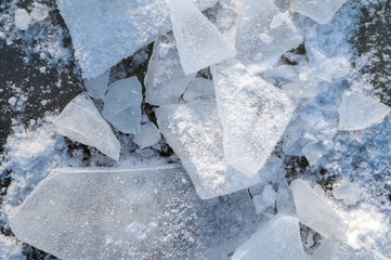 Cold Ice Crystals Shattered on Dark Surface With Frosty Snow and Blue Tones © Giedrius